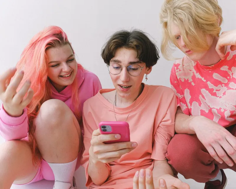 Jovens animados olhando juntos a tela do celular
